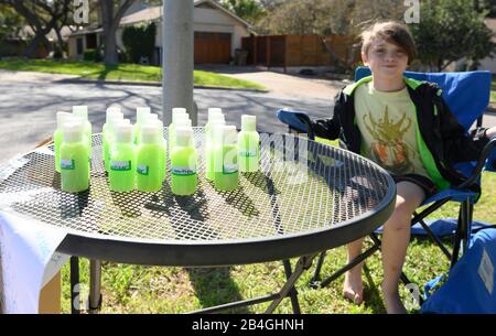 Le stand de désinfectant pour les mains remplace le stand de limonade alors que L'entrepreneur Miles Miller vend de l'aseptisant pour les mains maison pour aider à combattre le coronavirus à 3 $ la bouteille dans son Austin, Texas, quartier après l'école. Banque D'Images