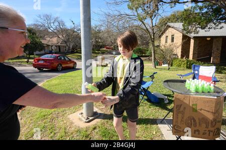 Le stand de désinfectant pour les mains remplace le stand de limonade alors que L'entrepreneur Miles Miller vend de l'aseptisant pour les mains maison pour aider à combattre le coronavirus à 3 $ la bouteille dans son Austin, Texas, quartier après l'école. Banque D'Images