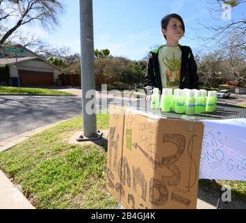 Le stand de désinfectant pour les mains remplace le stand de limonade alors que L'entrepreneur Miles Miller vend de l'aseptisant pour les mains maison pour aider à combattre le coronavirus à 3 $ la bouteille dans son Austin, Texas, quartier après l'école. Banque D'Images