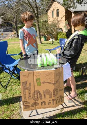 L'assainisseur pour les mains remplace la limonade alors que les jeunes entrepreneurs Miles Miller et Louis Spindle vendent de l'aseptisant pour les mains maison pour aider à combattre le coronavirus pour 3 $ une bouteille dans leur Austin, Texas, quartier après l'école. Banque D'Images