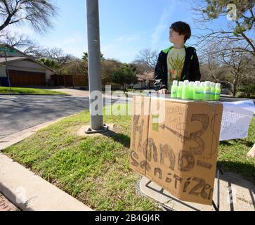 Le stand de désinfectant pour les mains remplace le stand de limonade alors que L'entrepreneur Miles Miller vend de l'aseptisant pour les mains maison pour aider à combattre le coronavirus à 3 $ la bouteille dans son Austin, Texas, quartier après l'école. Banque D'Images