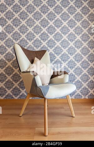 Chaise décorative sur le fond du mur avec papier peint en papier Banque D'Images
