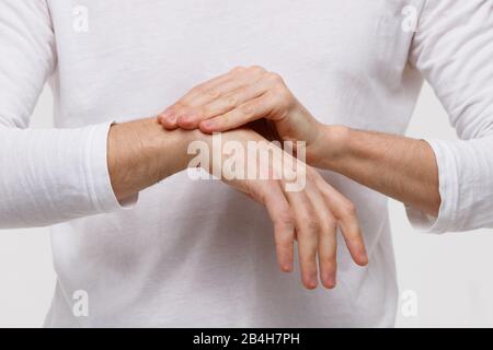 Gros plan sur les bras de l'homme tenant son poignet douloureux causé par un travail prolongé sur l'ordinateur, ordinateur portable. Syndrome du tunnel carpien, arthrite, désea neurologique Banque D'Images