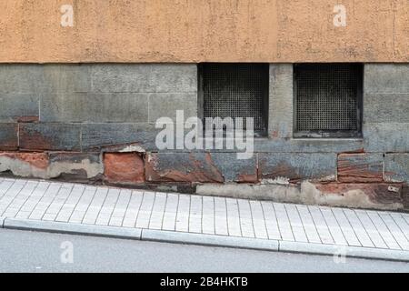 Un ancien bâtiment résidentiel avec cave windows sur une passerelle avec la pente. Banque D'Images