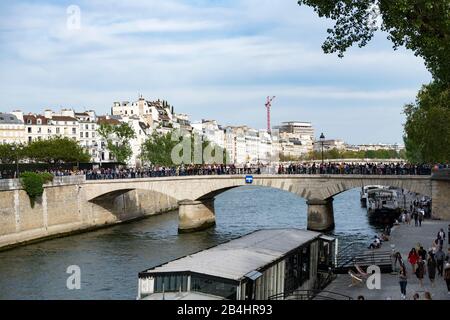 De nombreux touristes traversent le Pont de l'Archevêché par la Seine à Paris Banque D'Images