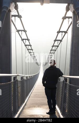 Allemagne, Saxe-Anhalt, Haute-Harz, un homme se tient sur le pont suspendu TitanRT, résine Rappbodetalsperre. Banque D'Images