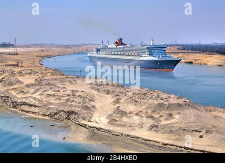 Le paquebot transatlantique Queen Mary 2 dans le canal de Suez (canal de Suez) entre dunes de sable, Egypte Banque D'Images