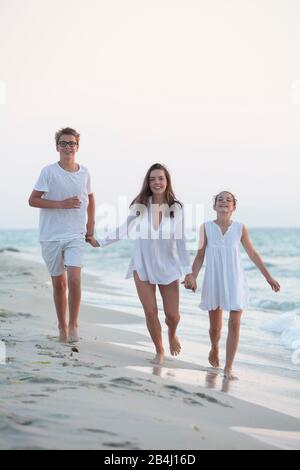 trois frères et sœurs marchent sur la plage Banque D'Images