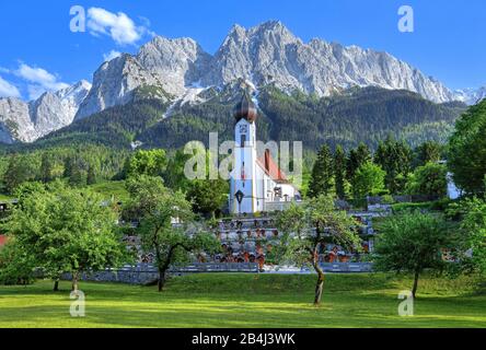 Village église au-dessus du cimetière contre Alpspitze 2628 m Waxenstein 2277m et Riffelwand le groupe Zugspitze dans les montagnes Wetterstein, Grainau, Werdenfelser Land, Zugspitzland, Haute-Bavière, Bavière, Allemagne Banque D'Images