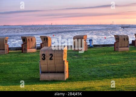 Plage d'herbe avec chaises de plage sur la mer des Wadden au soleil le soir, station balnéaire de la mer du Nord Wremen, Land Wursten, estuaire du Weser, mer du Nord, côte de la mer du Nord, parc national de la mer des Wadden de Basse-Saxe, Allemagne Banque D'Images