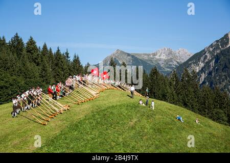 Autriche, Vorarlberg, petit Walsertal, Baad, Alphorn Festival, Alphorn souffleur, pré. Banque D'Images