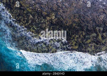 Des vagues dans rocky surf, Caleta de Famara, drone abattu, Lanzarote, îles Canaries, Espagne Banque D'Images