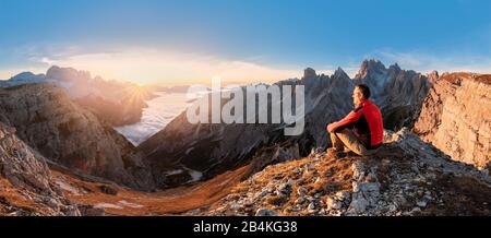 Randonneur admirant les Dolomites au lever du soleil devant Cadini di Meurina, Auronzo di Cadore, Belluno, Vénétie, Italie Banque D'Images