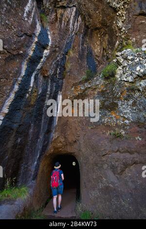 Randonneurs devant le tunnel Tunel do Pioo do Gato sur le sentier de randonnée de Pousada do Arieiro à Pico Ruivo, Parque Natural da Madeira, Madère, Portugal Banque D'Images