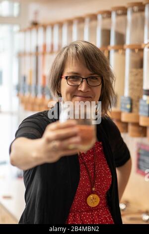 Eine Frau hält ein Glas mit Linsen in der Hand, Detail aus einem Unverpacktladen. Banque D'Images