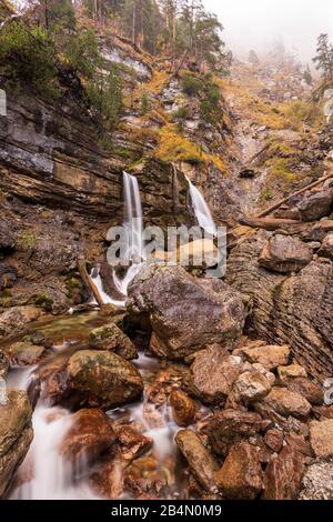 Chutes d'eau de Kuhflucht à Farchant dans les Alpes bavaroises près de Garmisch-Partenkirchen en automne. De grandes pierres se trouvent dans la gorge, à l'arrière-plan de la chute d'eau Banque D'Images