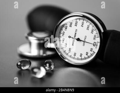 Santé et tension artérielle. Capsules Omega-3 assis le long de la jauge d'un sphygmomanomètre et de la tête d'un stéthoscope. Banque D'Images