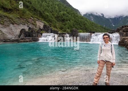 Les touristes chinois se trouvent devant les nombreuses chutes d'eau de Blue Moon Valley au pied De Jade Dragon Snow Mnt (Yulong Xue Shan) à Lijiang, Yunnan Banque D'Images