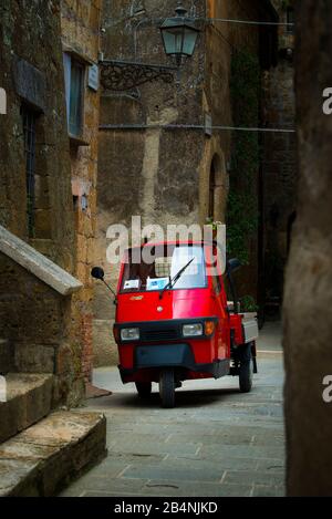 Pitigliano, Toscane, Italie, petite voiture rouge dans une ruelle de la vieille ville Banque D'Images
