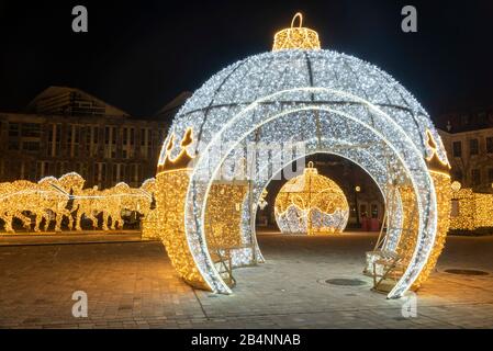 Deutschland, Sachsen-Anhalt, Magdeburg, auf dem Domplatz stehen beleuchtete Weihnachtskugeln und Pferde, die den berühmten Magdeburger Halbkugelversuc Banque D'Images