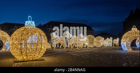 Deutschland, Sachsen-Anhalt, Magdeburg, auf dem Domplatz stehen beleuchtete Weihnachtskugeln und Pferde, die den berühmten Magdeburger Halbkugelversuc Banque D'Images