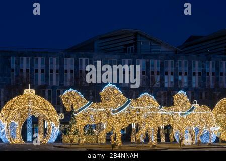 Deutschland, Sachsen-Anhalt, Magdeburg, auf dem Domplatz stehen beleuchtete Weihnachtskugeln und Pferde, die den berühmten Magdeburger Halbkugelversuc Banque D'Images