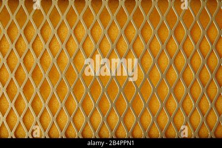 Texture en mesh métallique et doublure en mousse jaune. Dans le caoutchouc mousse, les pores sont clairement visibles. Banque D'Images