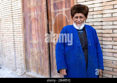 L'ouzbek porte un chapeau de fourrure et des vêtements traditionnels, Ouzbékistan, Boukhara Banque D'Images