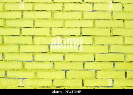 Texture et fond de brique avec peinture jaune. Gros plan. Banque D'Images