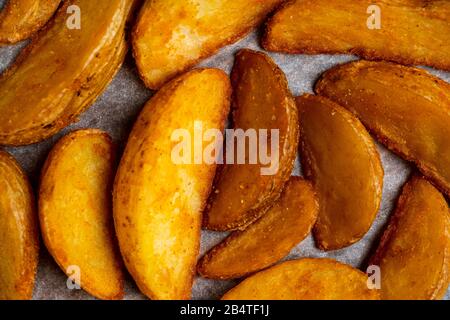 Pommes de terre frites rustiques sur fond de papier. Vue de dessus. Gros plan. Banque D'Images