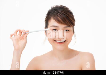 Peau parfaite. face belle asian woman applying makeup blush yeux colorés, cosmétiques et soins Banque D'Images