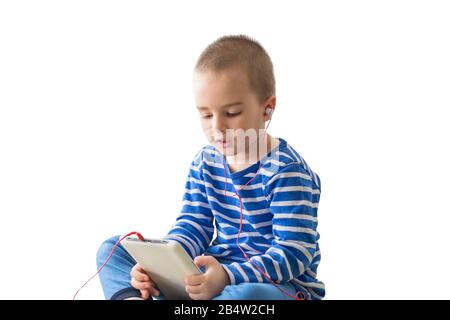 Joli garçon d'enfant dans un casque regardant la vidéo sur une tablette Banque D'Images