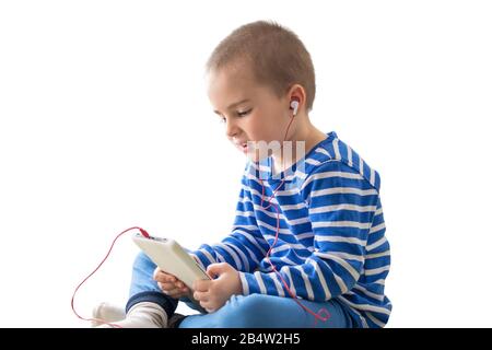 Joli garçon d'enfant dans un casque regardant la vidéo sur une tablette Banque D'Images