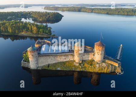 L'ancienne forteresse suédoise Olavinlinna dans le paysage d'été du matin (photographie aérienne). Savonlina, Finlande Banque D'Images