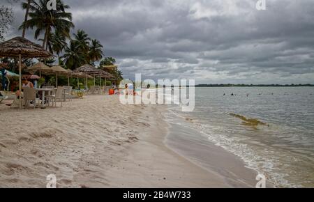 Les Familles françaises qui profitent d'une journée sur la plage de Port Gentil pendant la saison de la pluie avec une couverture nuageuse. Banque D'Images