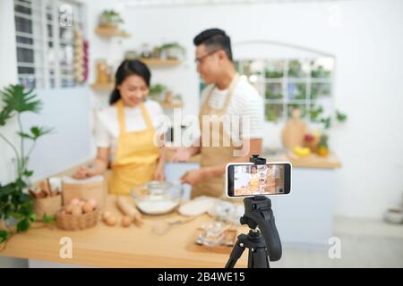 Young Asian Woman cooking together et l'enregistrement de la vidéo en direct de vlog et médias sociaux avec appareil photo professionnel Banque D'Images