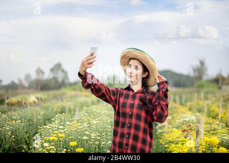 portrait de la belle femme asiatique dans le champ de fleurs de la nature. concept d'agriculteurs heureux Banque D'Images