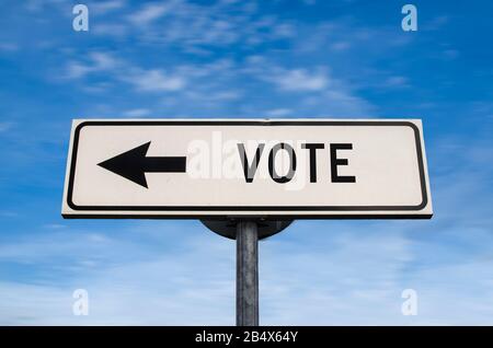 Votez le panneau de route, flèche sur fond bleu ciel. Panneau de route vierge à sens unique avec espace de copie. Flèche sur un poteau pointant dans une direction. Élection. Banque D'Images