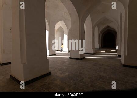 Femme debout dans une arche blanche, colonnes, intérieur de Kalan, Mosquée de Kalon, Boukhara, Bouchara, site du patrimoine mondial de l'UNESCO, Ouzbékistan, Asie centrale Banque D'Images