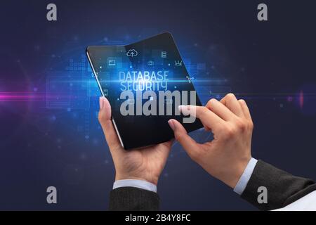 Businessman holding a smartphone pliable avec la sécurité de la base de l'inscription, concept de sécurité cybernétique