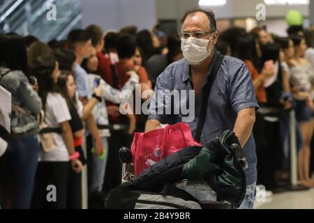 Sao Paulo, Brésil. 7 mars 2020. Un passager porte un masque à son arrivée à l'aéroport international de Guarulhos, en périphérie de Sao Paulo, Brésil, le 7 mars 2020. Au Brésil, le nombre de cas confirmés de COVID-19 est passé à 13. Parmi eux, 10 cas ont été enregistrés dans la municipalité de Sao Paulo, et les trois autres dans les États de Rio de Janeiro, Espirito Santo et Bahia, respectivement. Crédit: Rahel Patrasso/Xinhua/Alay Live News Banque D'Images