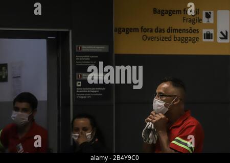 Sao Paulo, Brésil. 7 mars 2020. Le personnel porte des masques à l'aéroport international de Guarulhos à la périphérie de Sao Paulo, Brésil, 7 mars 2020. Au Brésil, le nombre de cas confirmés de COVID-19 est passé à 13. Parmi eux, 10 cas ont été enregistrés dans la municipalité de Sao Paulo, et les trois autres dans les États de Rio de Janeiro, Espirito Santo et Bahia, respectivement. Crédit: Rahel Patrasso/Xinhua/Alay Live News Banque D'Images