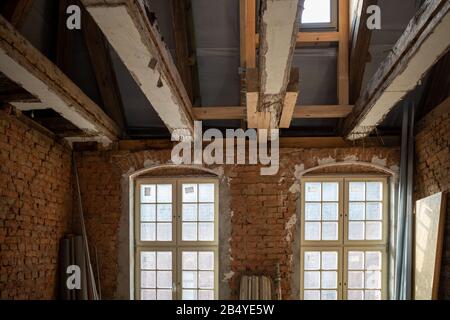 dans un ancien bâtiment en cours de restauration, de vieilles poutres en bois sont renforcées par de nouvelles poutres Banque D'Images