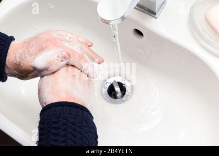 Personne se laver les mains avec de l'eau et du savon dans un évier Banque D'Images