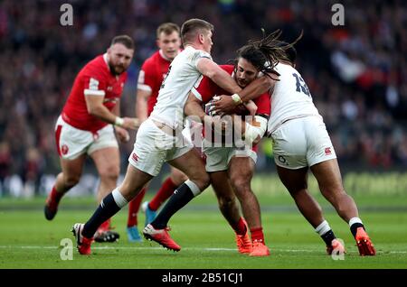 Josh Navidi (centre) du Pays de Galles est traité par Owen Farrell (gauche) et Manu Tuilagi (droite) de l'Angleterre lors du match Guinness Six Nations au stade de Twickenham, Londres. Banque D'Images