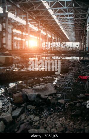 Vieux masque à gaz soviétique pourri sur le sol sale de l'usine abandonnée. Banque D'Images