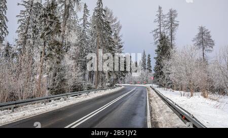 Route d'asphalte noire enneigée dans les montagnes de Tatra Banque D'Images