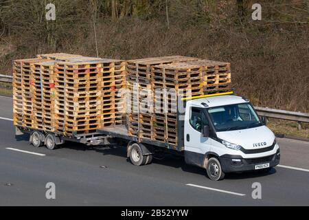 Palettes en bois sur une fourgonnette et une remorque Iveco à lit plat ; industrie du transport, M61 à Manchester, Royaume-Uni Banque D'Images