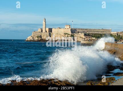 Faro Castillo del Morro à la Havane, Cuba est un phare construit en 1845 qui garde le port de la Habana. Vagues sur l'esplanade El Malecón. Banque D'Images