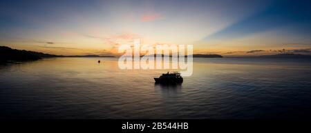 Une paisible silhouettes d'aube une vie à bord d'un bateau de plongée dans la baie d'Alyui, Raja Ampat. Cette partie de l'Indonésie abrite une extraordinaire biodiversité marine. Banque D'Images